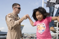フレンドシップデーで女の子を航空機から降ろす海兵隊員